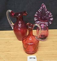 Three cranberry glass pieces grouped