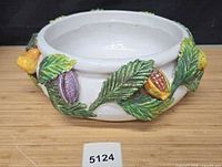 Top and side view of ceramic bowl with fruit and leaf decorations