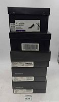 Stack of six designer shoe boxes with labels visible