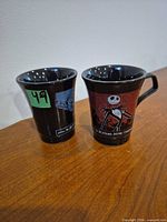 Two Nightmare Before Christmas ceramic cups showing both graphics