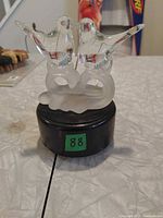 Front view of lamp showing two glass birds on frosted perch, black base with lot sticker