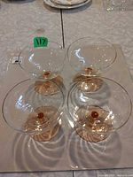Top view of four champagne glasses arranged together showing bowls and peach bases