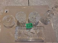 All five crystal pieces laid out: rectangular tray, pitcher, lidded dish, small bowl, mini glass