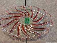 Top view of clear glass serving dish showing red striped swirl design and divided sections