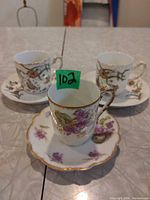 Three Limoges demitasse cup and saucer sets with assorted patterns