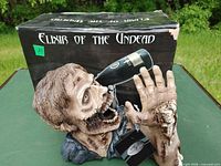 Zombie wine holder in front of product box