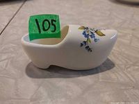 Side view of miniature china shoe showing shape and blue floral design