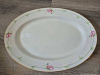 Top view showing full platter design, rose pattern, gold rim