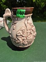 Full view of pitcher showing front tavern scene and handle