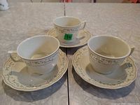 Three teacups with saucers showing pattern