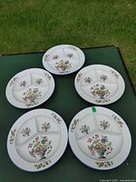 Five three-segment floral plates displayed