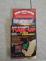 Front covers of the three Petersen softcover automotive manuals stacked