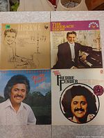 Four LP covers: two Liberace albums, two Freddy Fender albums