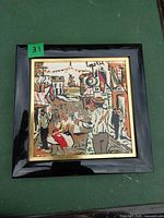Front view of framed painted ceramic tile village scene