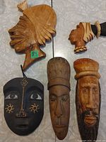 Front view of the five wooden face carvings