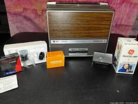 Front view of Bell & Howell projector with accessories laid out