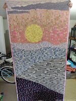 Full view of rectangular quilt front with sun and landscape design