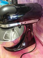 Left side view of black KitchenAid mixer with bowl and flat beater attached