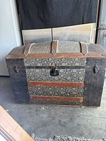 Closed dome-top trunk exterior showing wood slats, metal hardware and lock