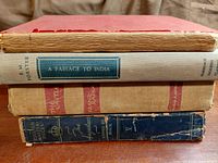 Stack of four hardcover books showing spines and wear