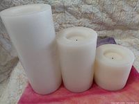 Front view showing three ivory wax LED pillar candles of different heights