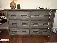 Front view showing six drawers with recessed handles and distressed finish