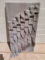 Front view of woven wall hanging showing full design and fringe