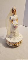 Front view of porcelain bride music box showing dress, veil, bouquet and base hearts pattern