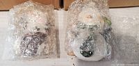Two bubble-wrapped snowman ornaments removed from box