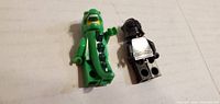 Front view of both minifigures lying on surface
