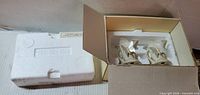 Styrofoam insert and open box showing two porcelain butterfly figurines inside