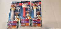 Front view of three packaged holiday PEZ dispensers