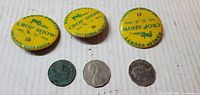 Front view of three Crop Show pinbacks and three coins
