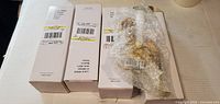 Four sealed white boxes labelled for lighted window candles