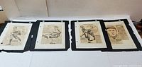 All four mounted caricature prints laid out