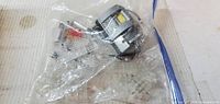 Ziplock bag holding numerous clear Lego elements and grey light-up brick