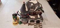Front view of ceramic village house with accessory stand and figurines