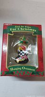 Front view of boxed Enesco ornament showing race car, flag, stopwatch design and series branding