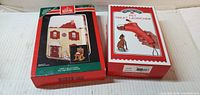 Front view of both sealed boxes: Hallmark Keepsake house ornament and Gourmet Trends pet treat launcher
