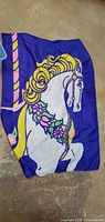 Full view of blue flag with carousel horse design