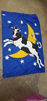 Full view of flag showing cow, moon and stars
