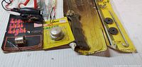 Overview of packaged automotive bulb, gas cap, knife, hold-down bolts, adapter, test light