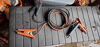 Full view of coiled jumper cables showing both orange and black clamps