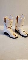 Front angle of both white ceramic cowboy boot figurines