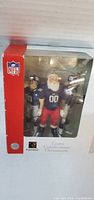 Angled front view of unopened box showing Santa and two Giants player figures inside