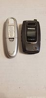 Back of silver USB thumb drive and front of closed Samsung Cingular flip phone
