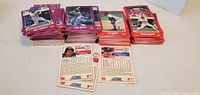 Front view showing three main stacks of Score baseball cards with purple and red bordered fronts, sample back cards visible