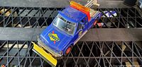Angled top view of blue Sunoco Ultra 94 tow truck with yellow plow and roof light bar
