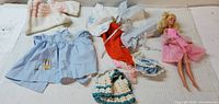 Lot overview showing Barbie doll and all clothing pieces spread out