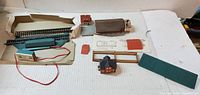Overview of wired track section, control box, freight depot shell, house, roof panels, wall section, base, instruction sheet